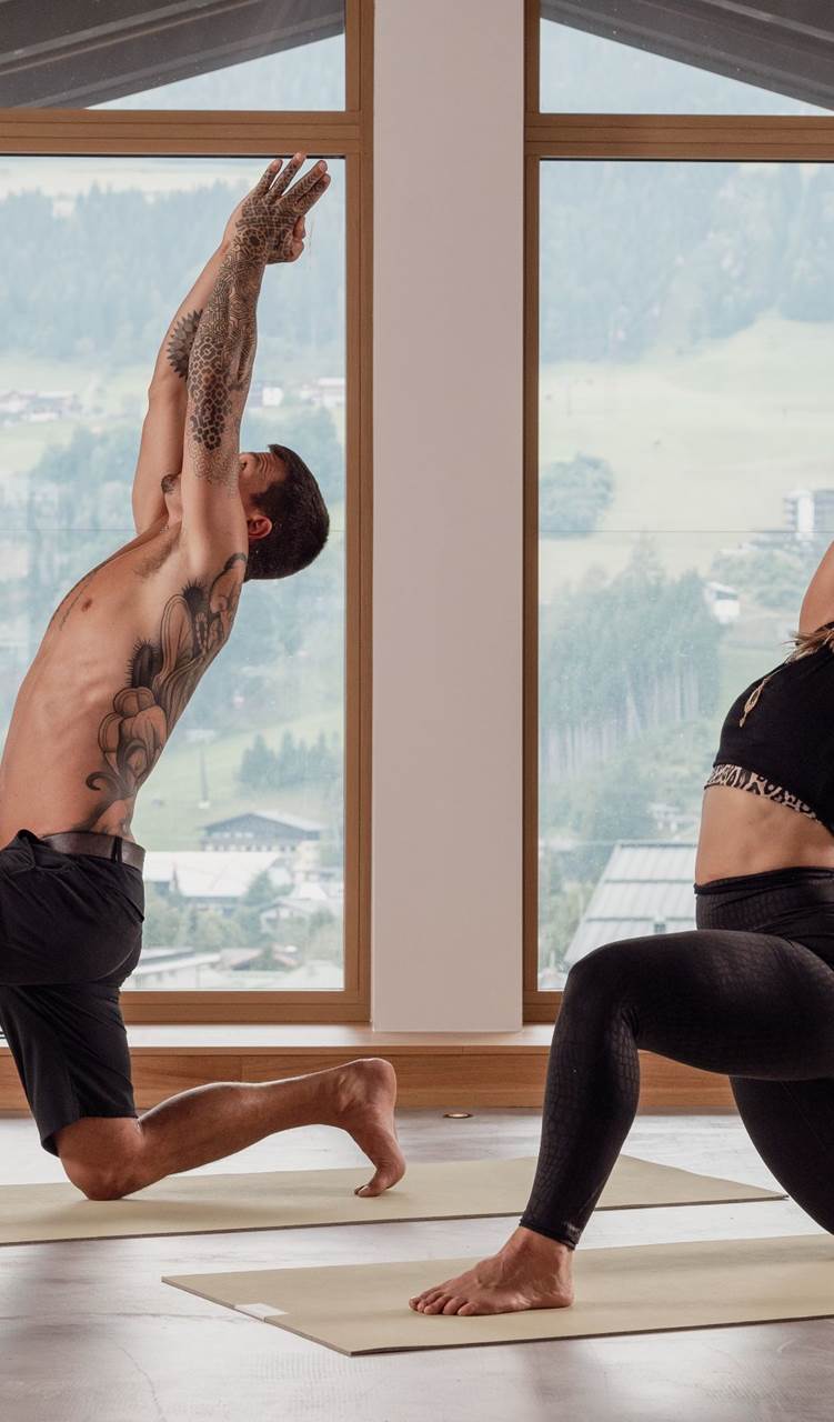 Zwei Personen beim Yoga in einem hellen Raum